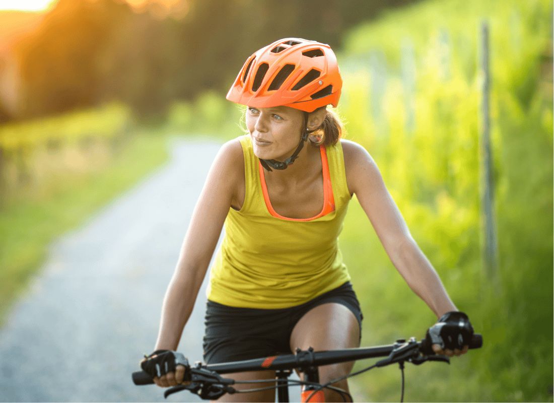 A woman riding a bike along a paved trail
