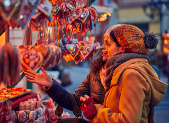 Two shoppers browsing holiday ornaments at a festive winter market, one of the many things to do in Bonney Lake during the holidays.